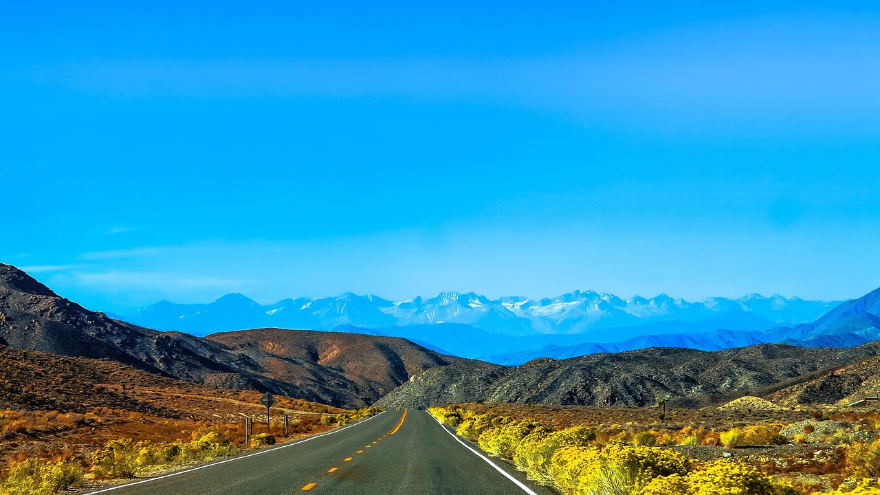 Serene view of a highway surrounded by lush green valleys.